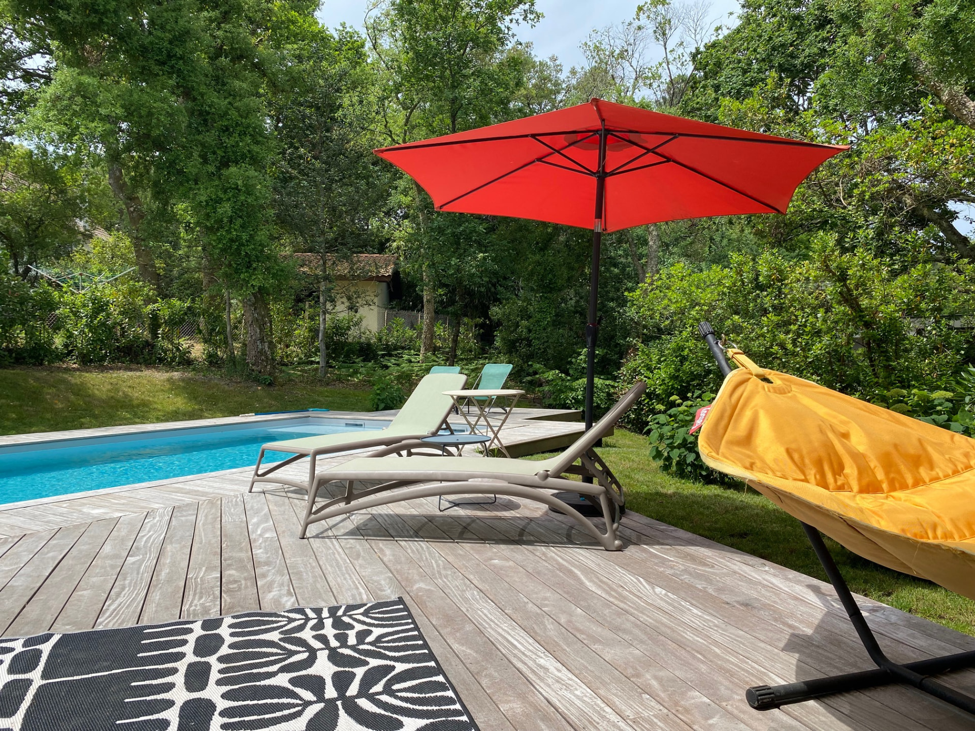 La terrasse en bois au bord de la piscine